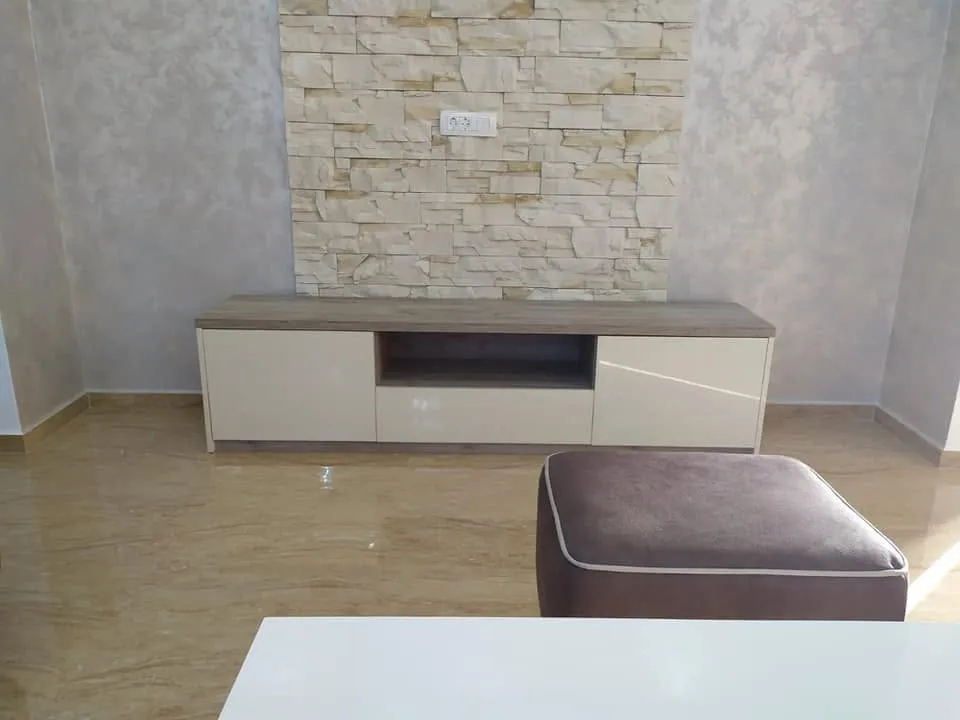 TV komoda ispred kamenog zida
